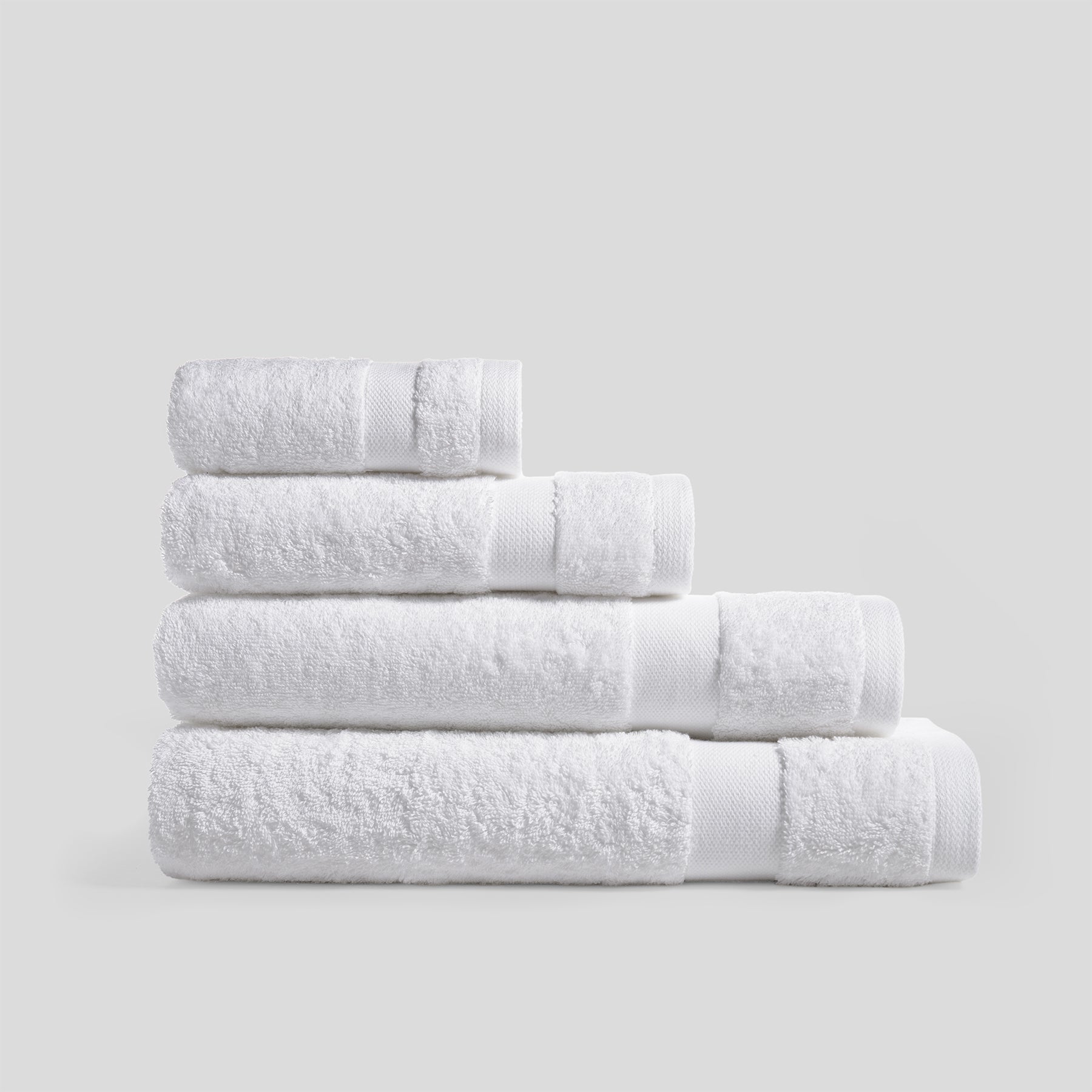 Stack of pure white bath towels in soft cotton for everyday bathroom use and modern home decor.