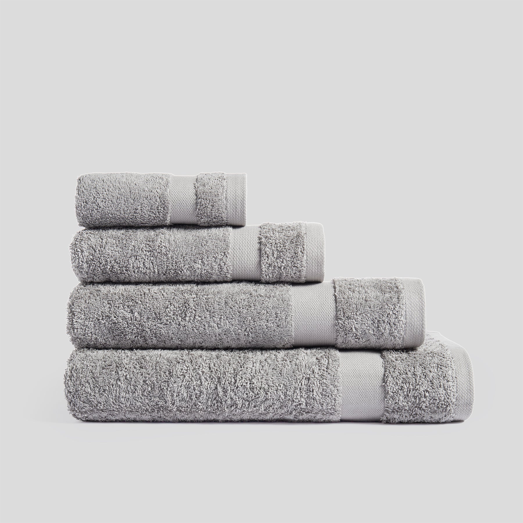 Stack of mist grey bath towels in soft cotton for everyday bathroom use and modern home decor.