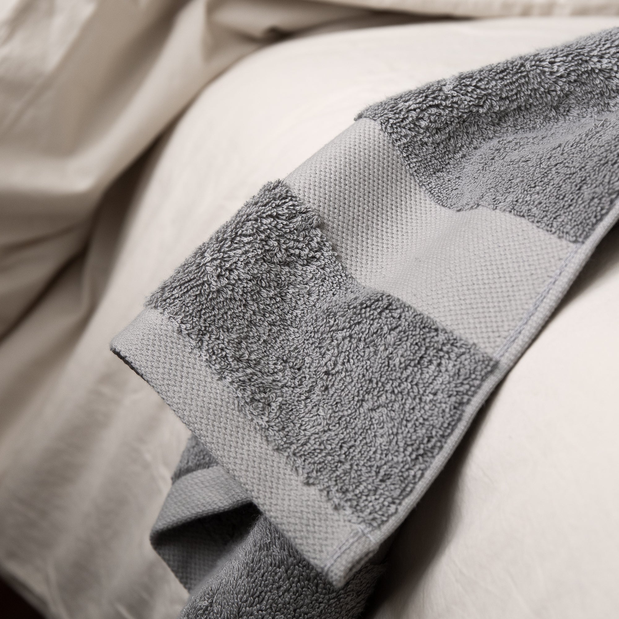 Close-up of Giza towel texture and border detail on a soft fabric surface.
