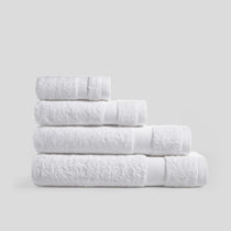 Stack of pure white bath towels in soft cotton for everyday bathroom use and modern home decor.