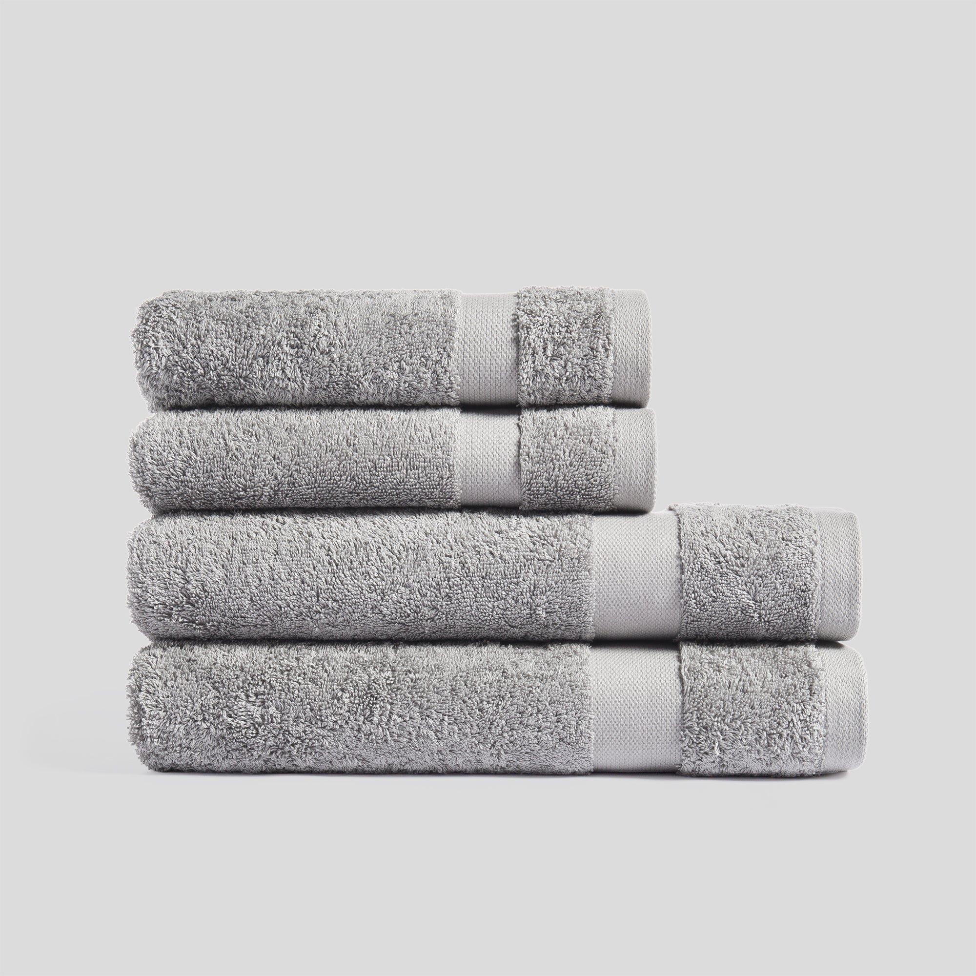 Stack of mist grey bath towels in soft cotton for everyday bathroom use and modern home decor.
