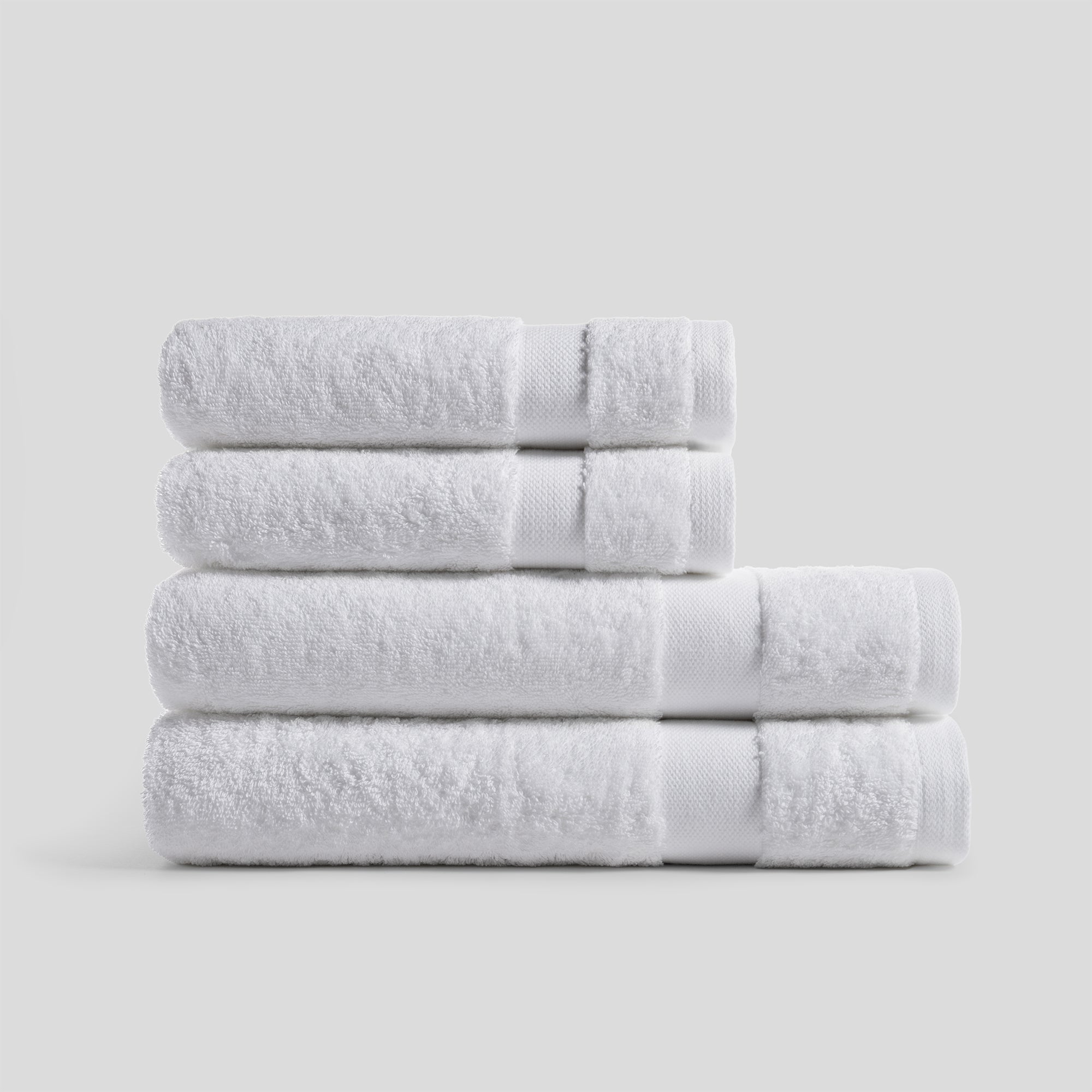 Pure white bathroom towel set made of soft absorbent cotton, ideal for modern home essentials.