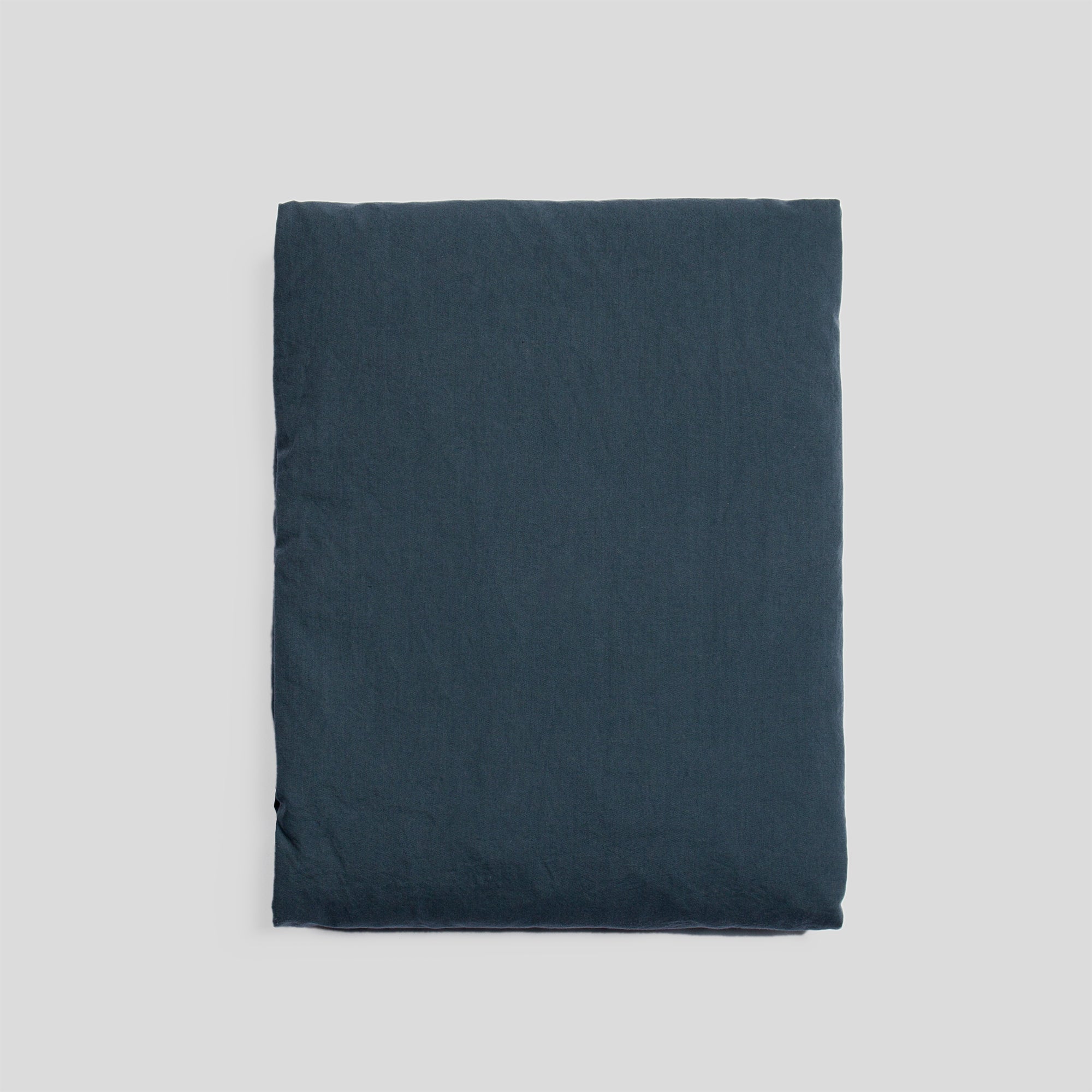 Atlantic blue organic cotton fitted sheet folded, ideal for fresh and minimalist bedroom style.