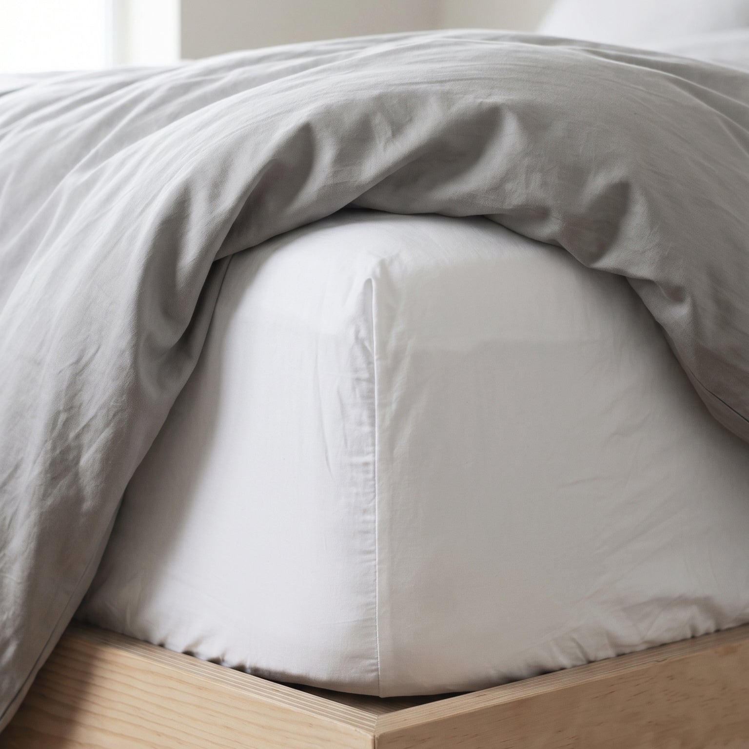 Fitted bed sheet styled on a minimalist bed with soft and smooth cotton texture.