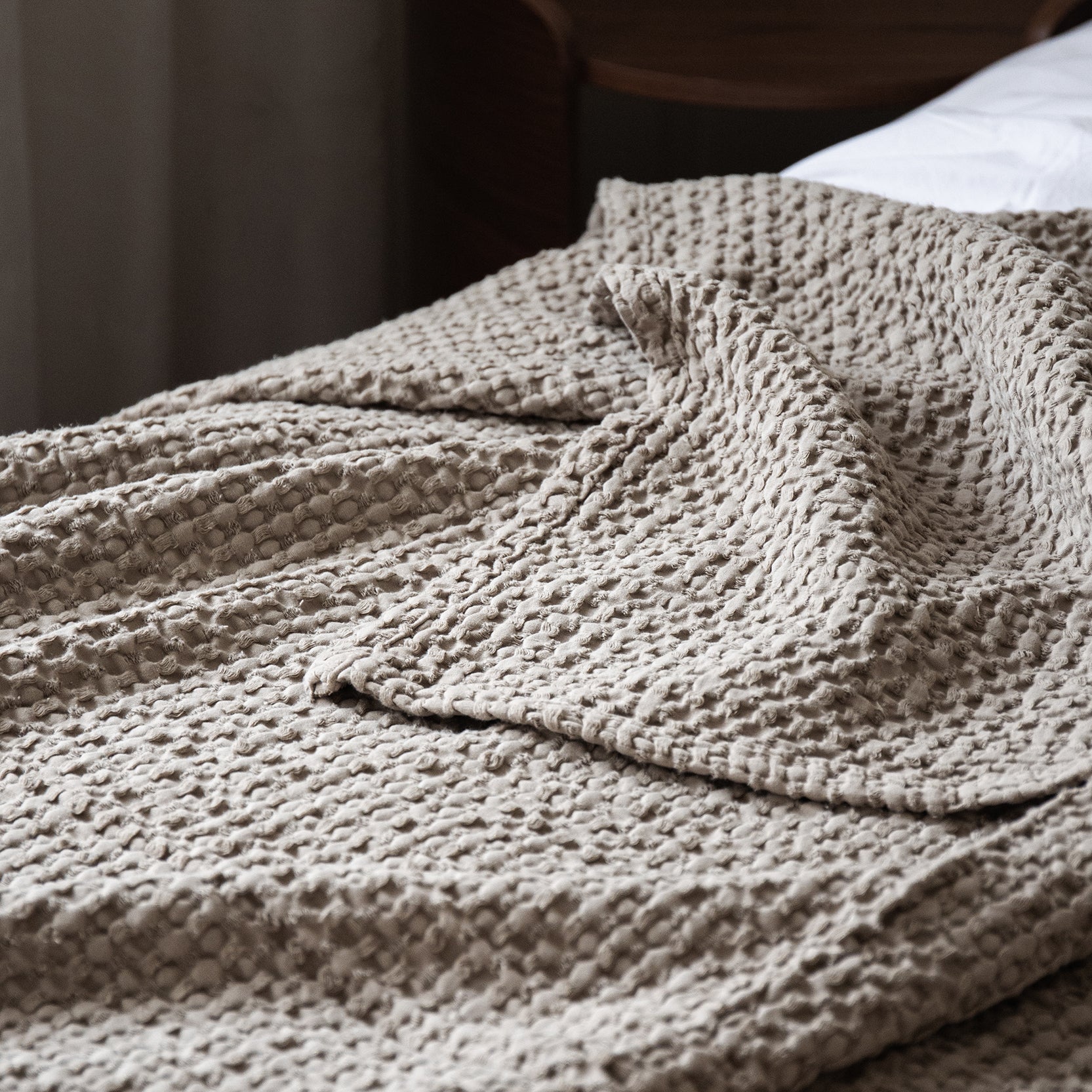 Textured bedspread styled on a bed with a relaxed and cozy finish.