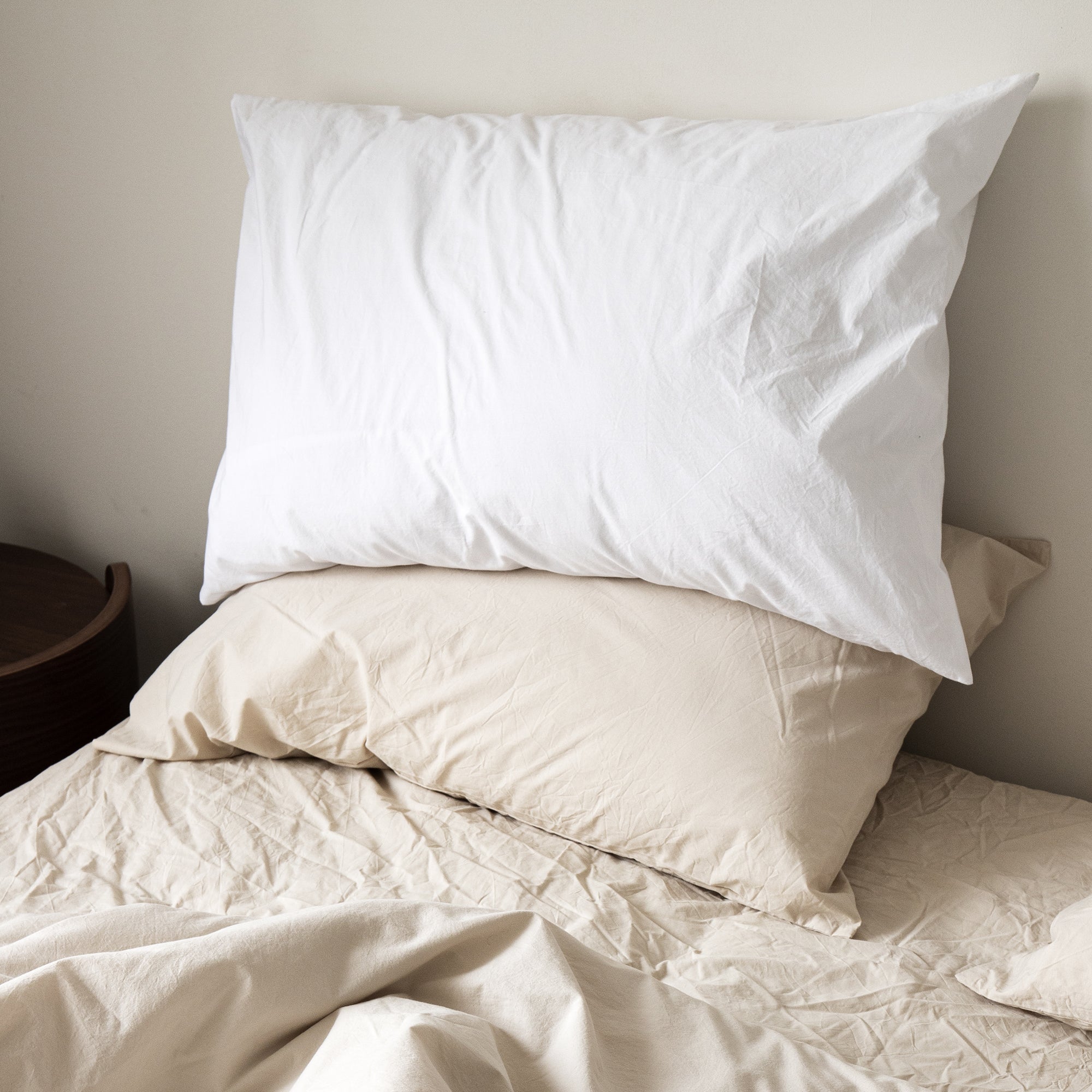Soft pillowcases layered on a bed with a casual and inviting look.