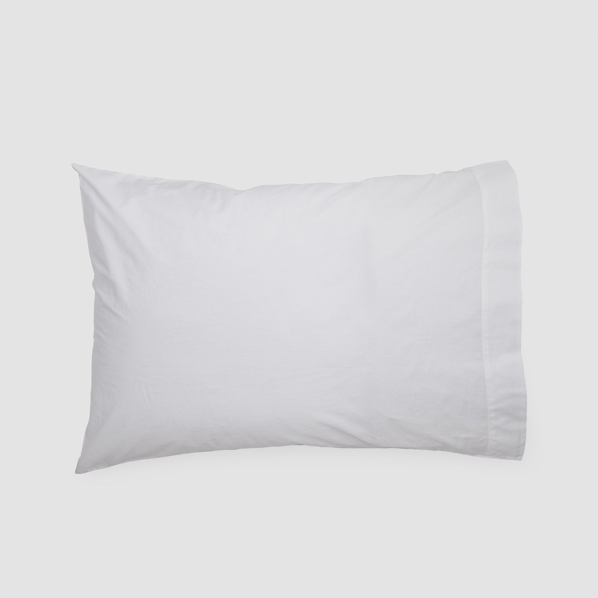 Pure white organic cotton pillowcase for elegant bedding and modern interiors.
