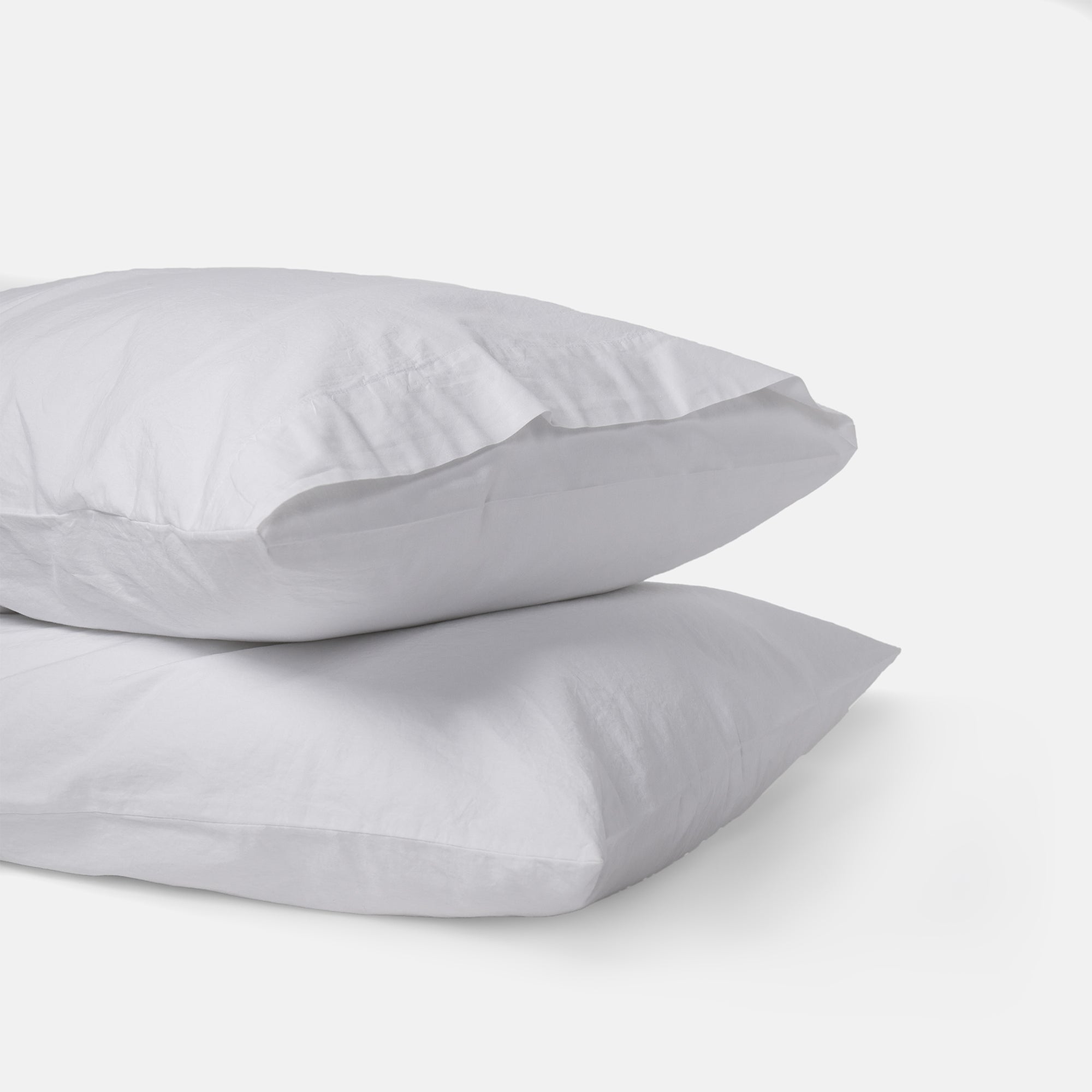 Set of two pure white pillowcases in organic cotton for a serene bedroom feel.