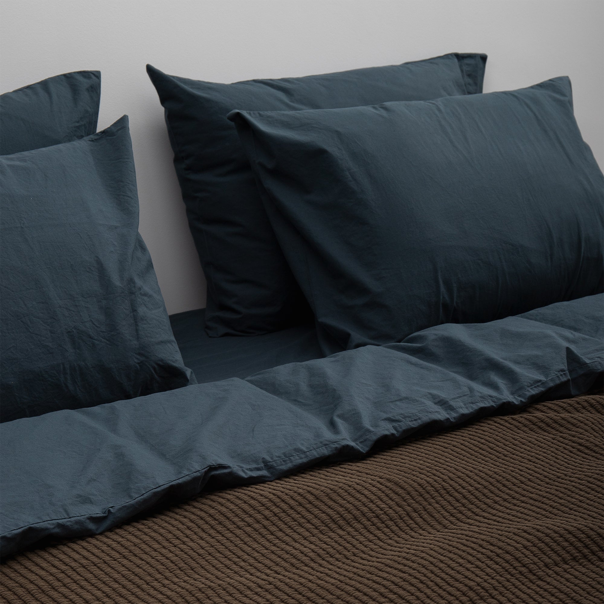 Duvet cover styled on a bed with layered pillows and a relaxed contemporary look.