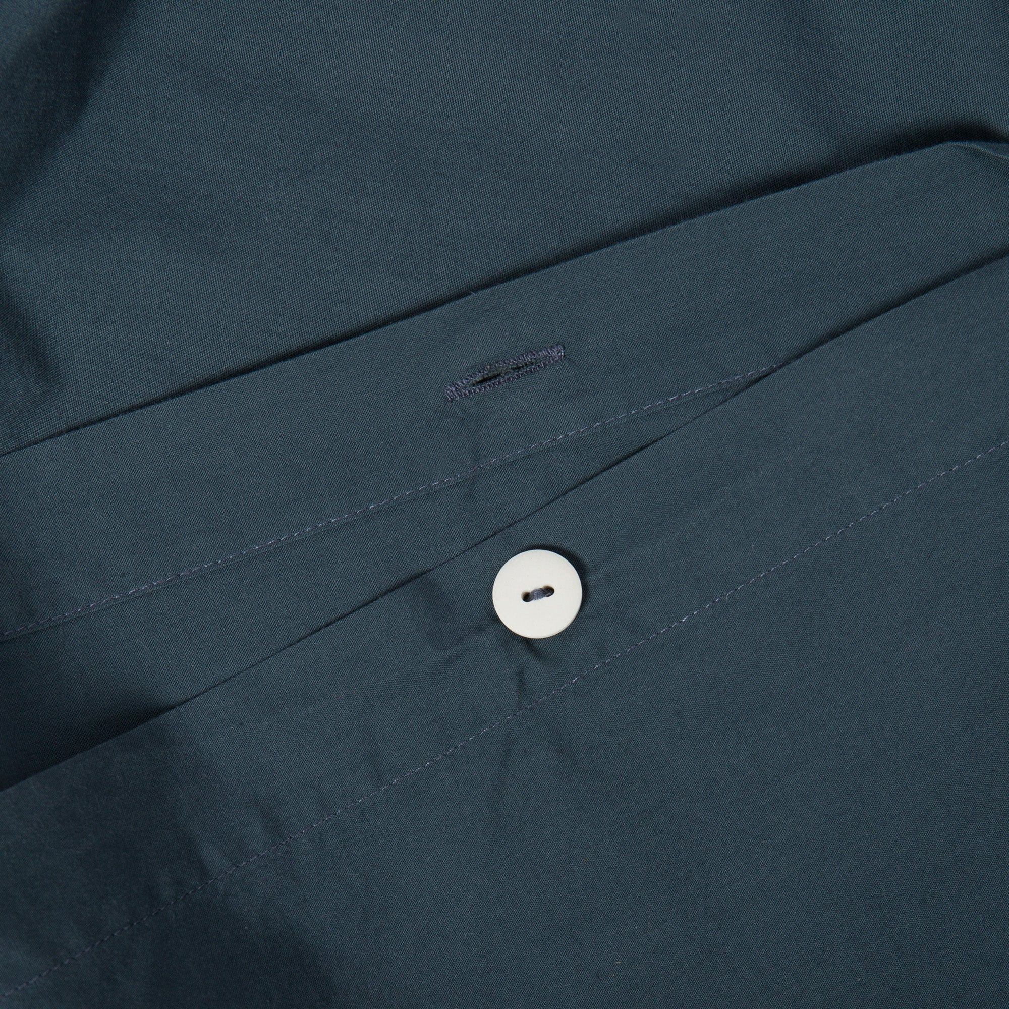 Close-up of button closure on atlantic blue organic cotton duvet cover.