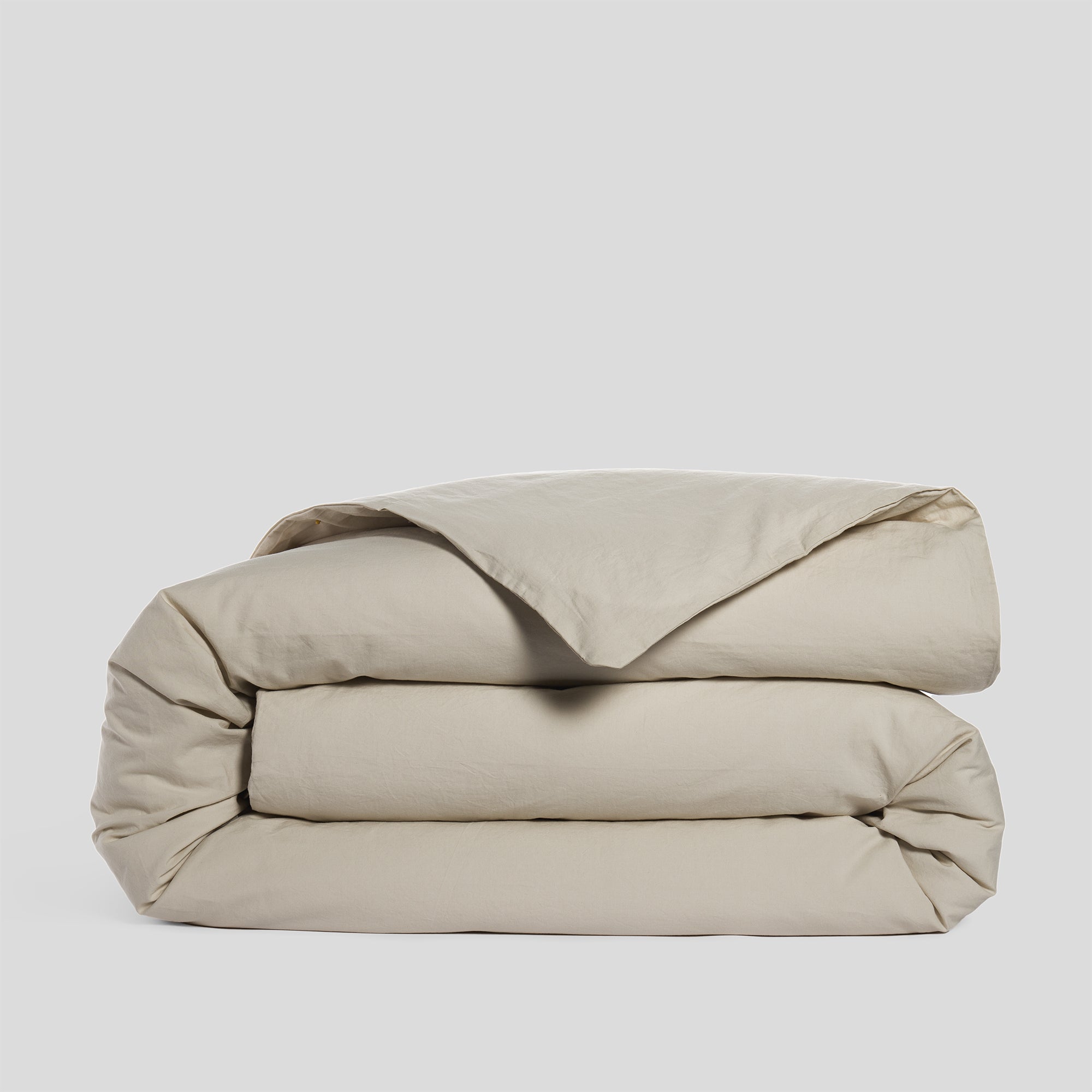 Folded sand duvet cover in soft and breathable organic cotton.
