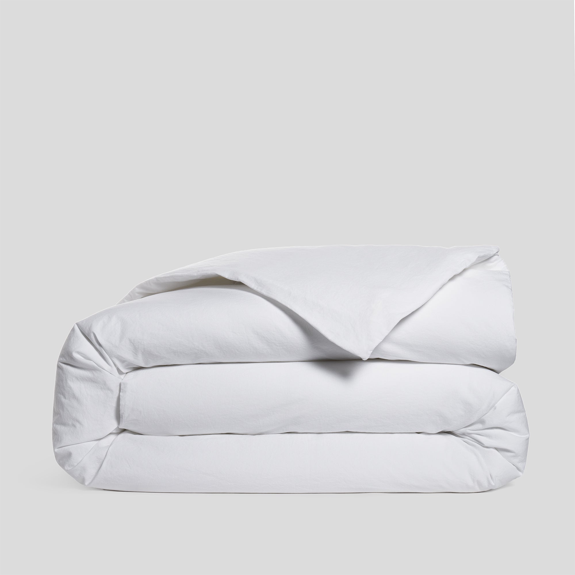 Folded pure white duvet cover in soft and breathable organic cotton.