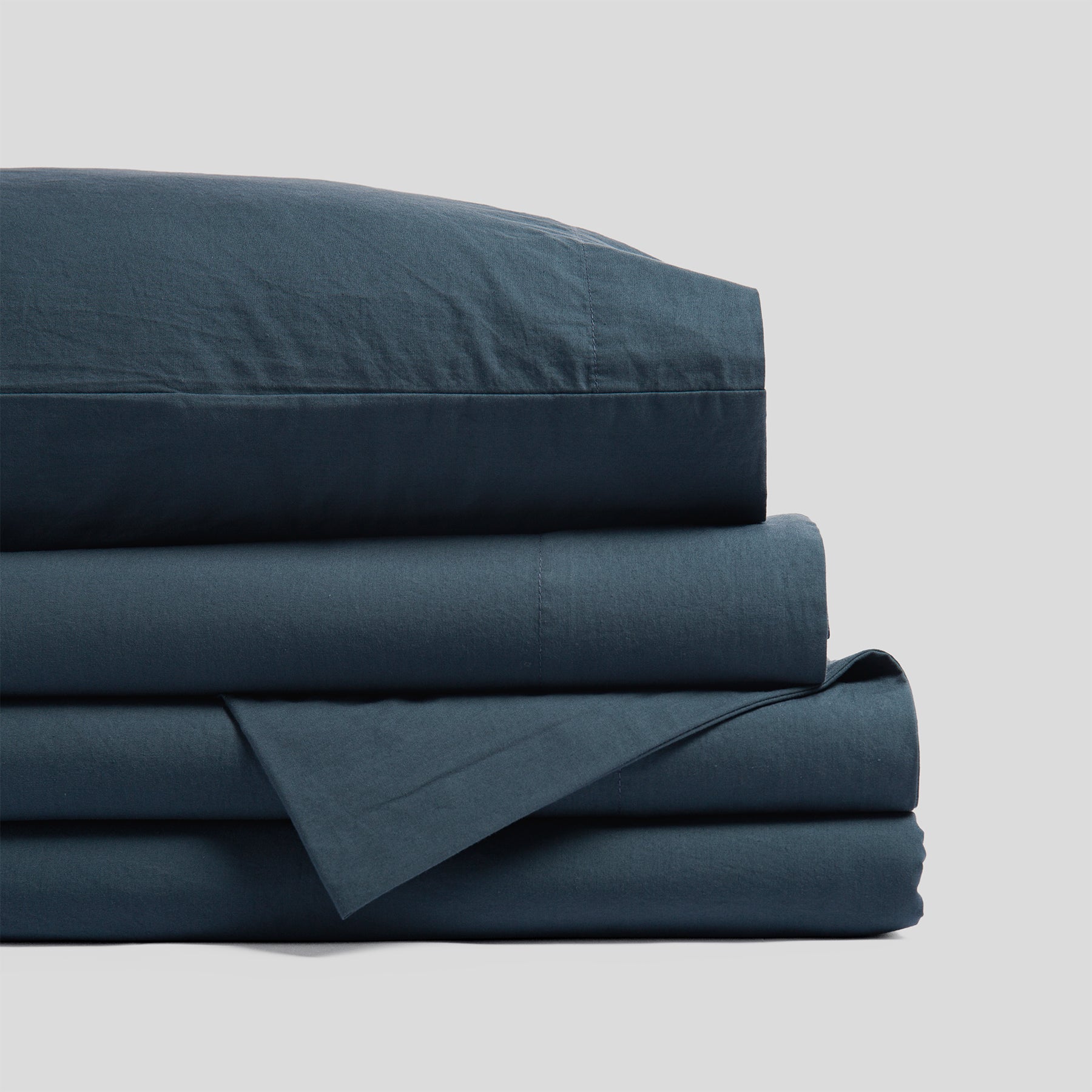 Folded organic cotton sheet set in atlantic blue with a smooth finish and soft fabric texture.