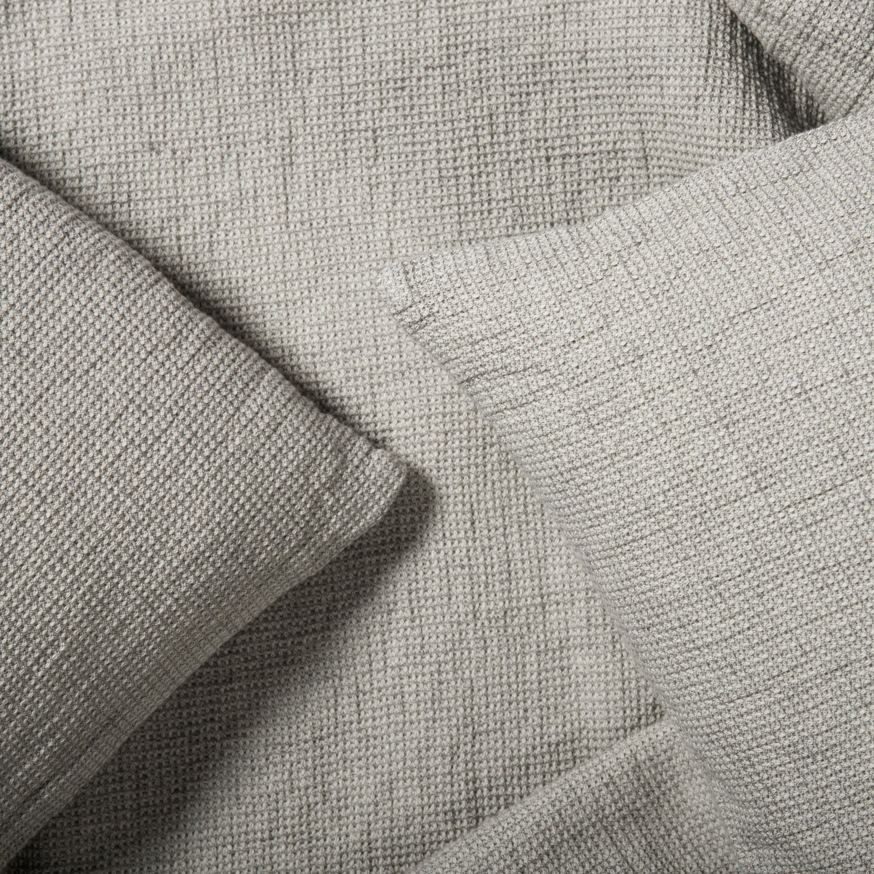 Close-up of waffle textured mist grey cushion cover made from natural woven fabric.