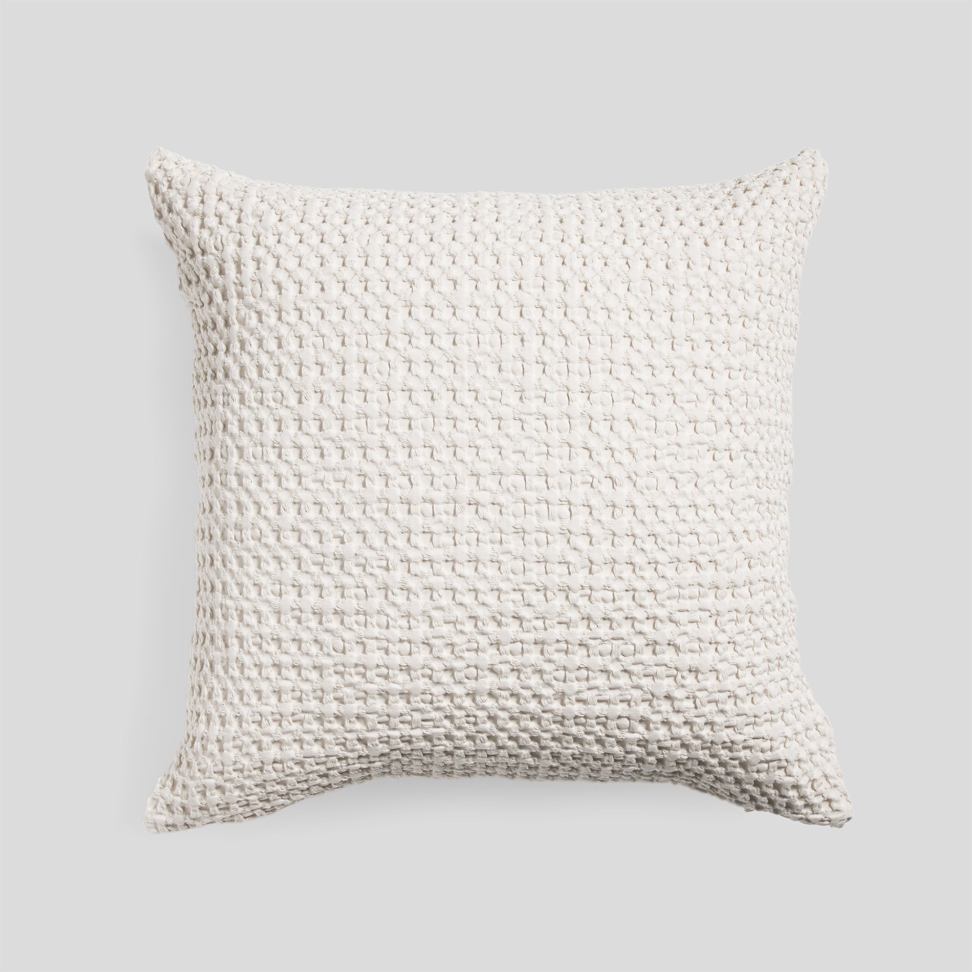 Cotton cushion cover in ivory with a soft waffle texture fabric.
