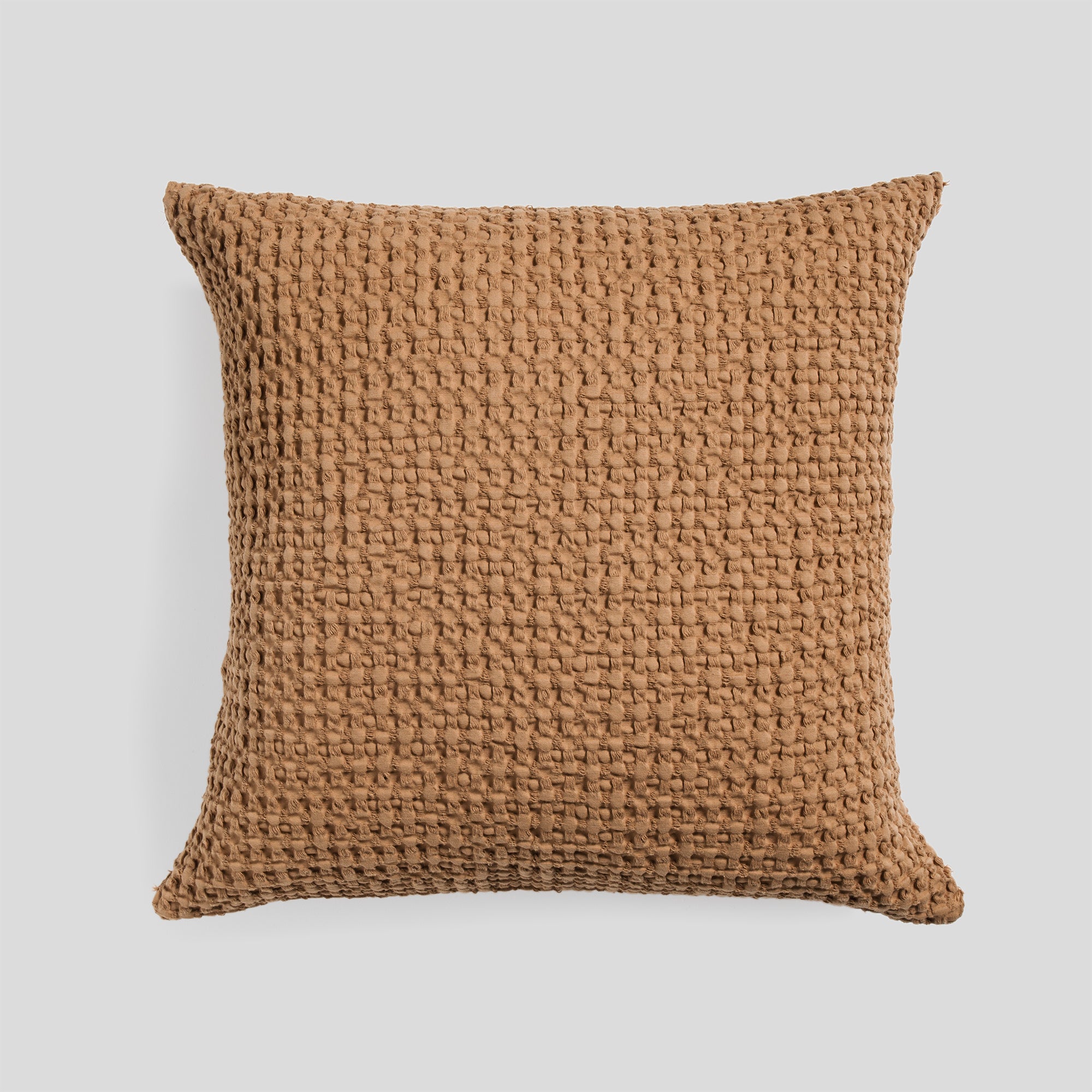 Cotton cushion cover in clay with a soft waffle texture fabric.