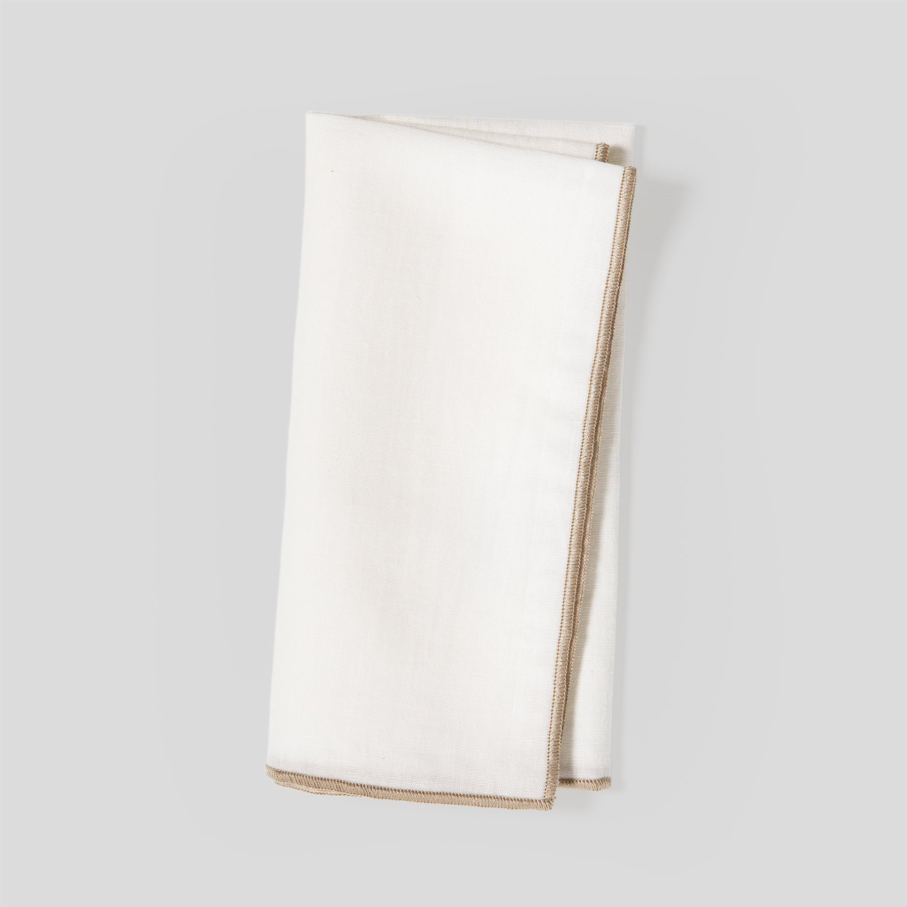 Folded linen and cotton napkins showing a natural fabric texture and sand overlock edge detail.