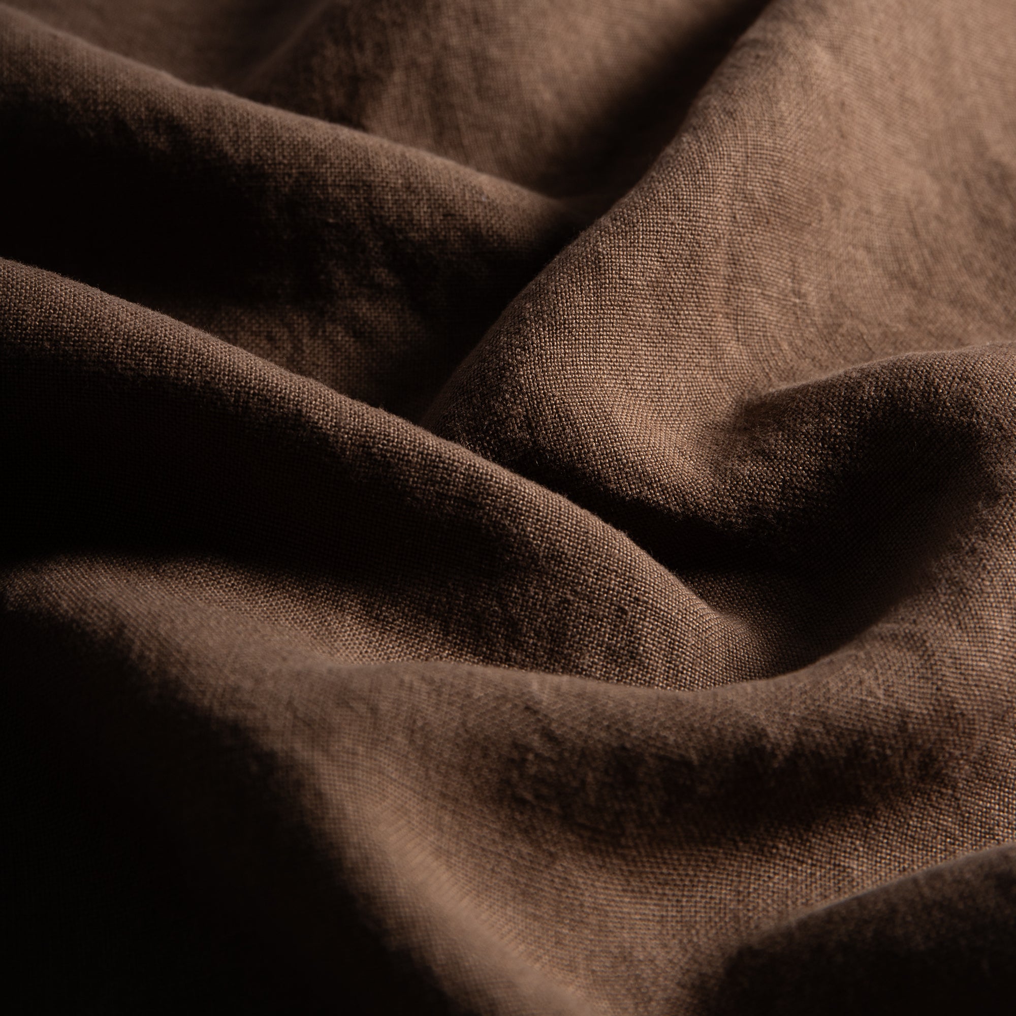 Close-up of sable linen napkin fabric with a soft and naturally textured finish.
