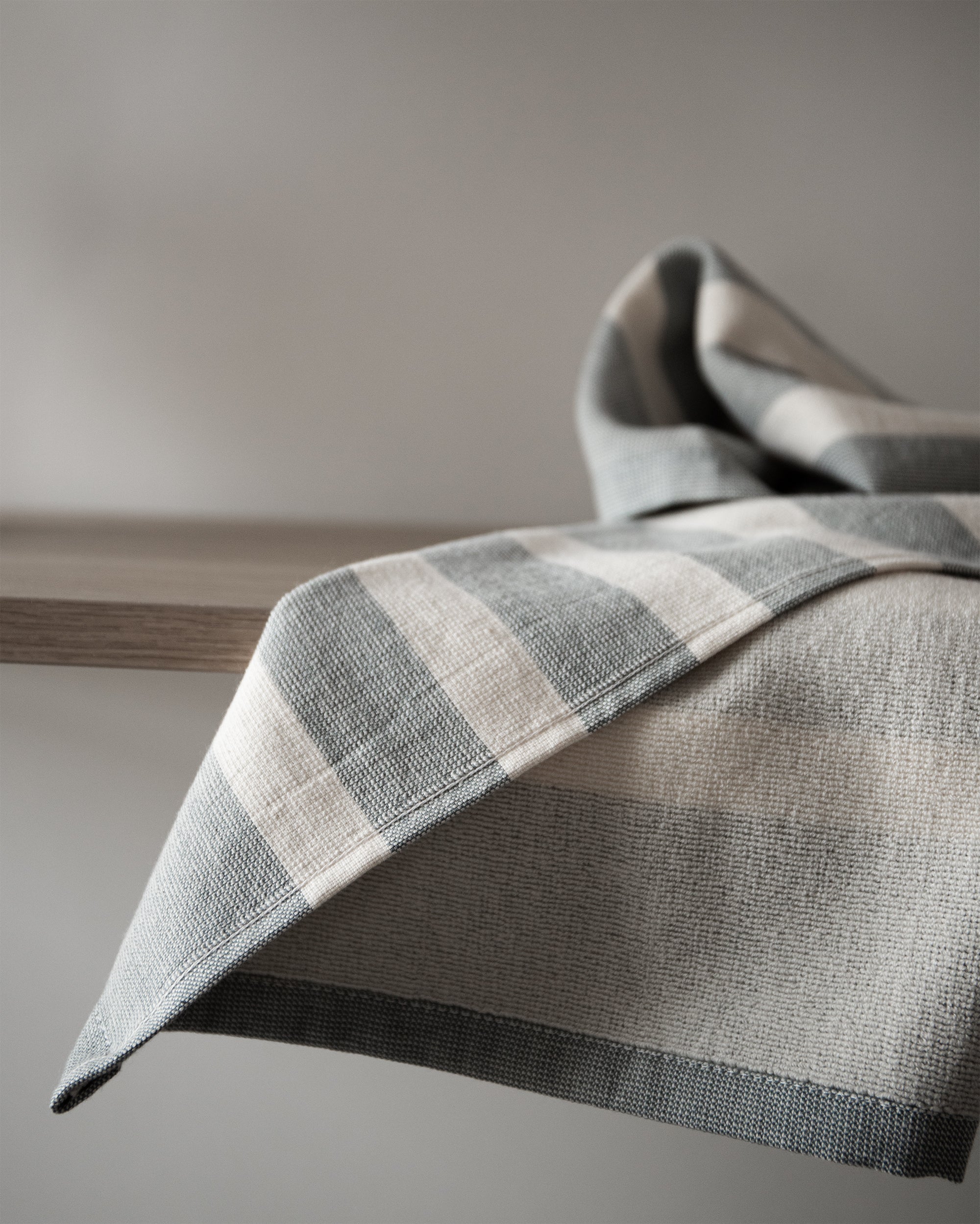 Close-up of a striped 100% cotton kitchen towel showcasing its woven texture and neatly finished edges.