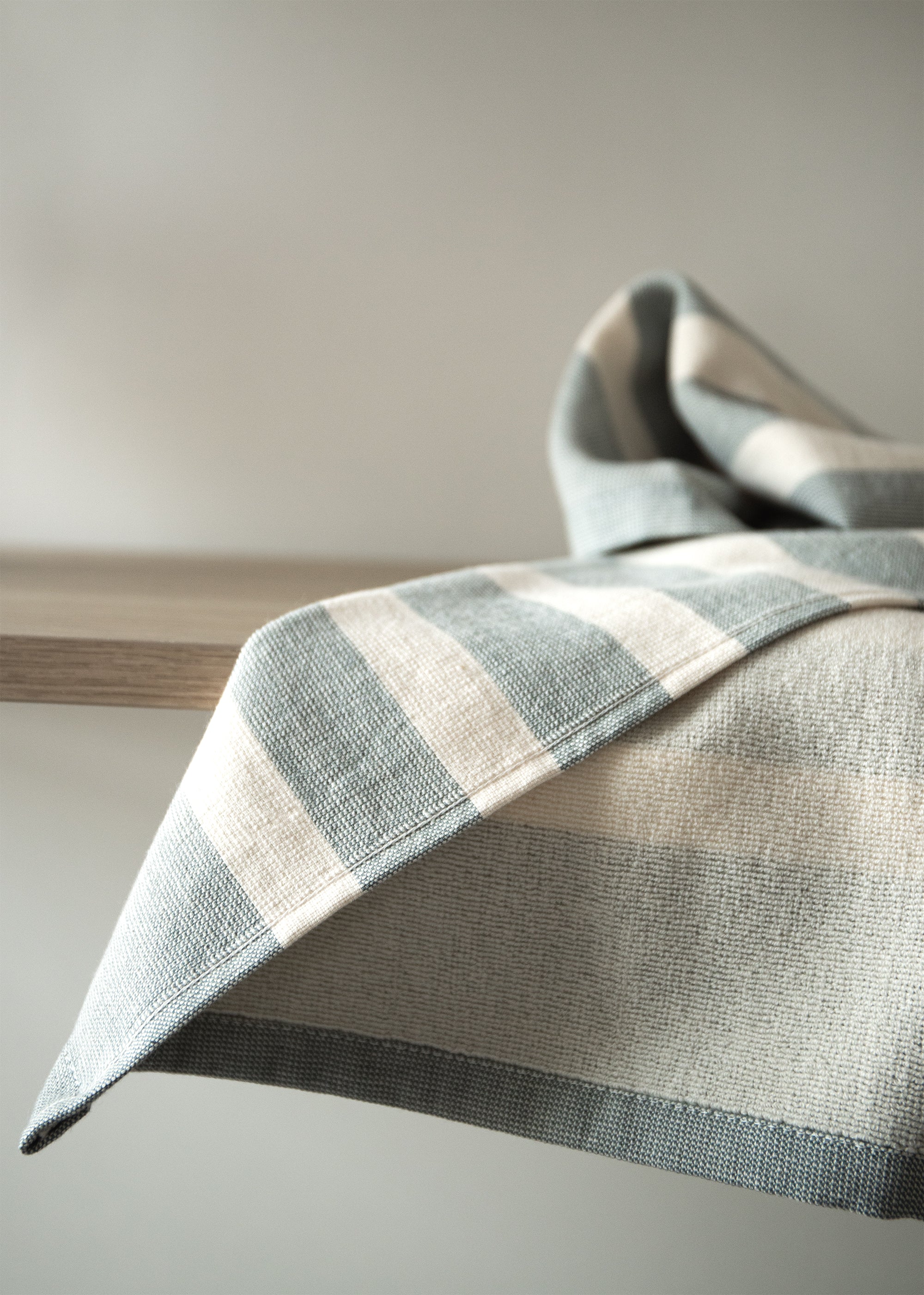 Close-up of a striped 100% cotton kitchen towel showcasing its woven texture and neatly finished edges.